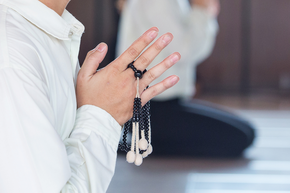 prayer and holding prayer book and jutsu beads in japanese buddhist nichiren